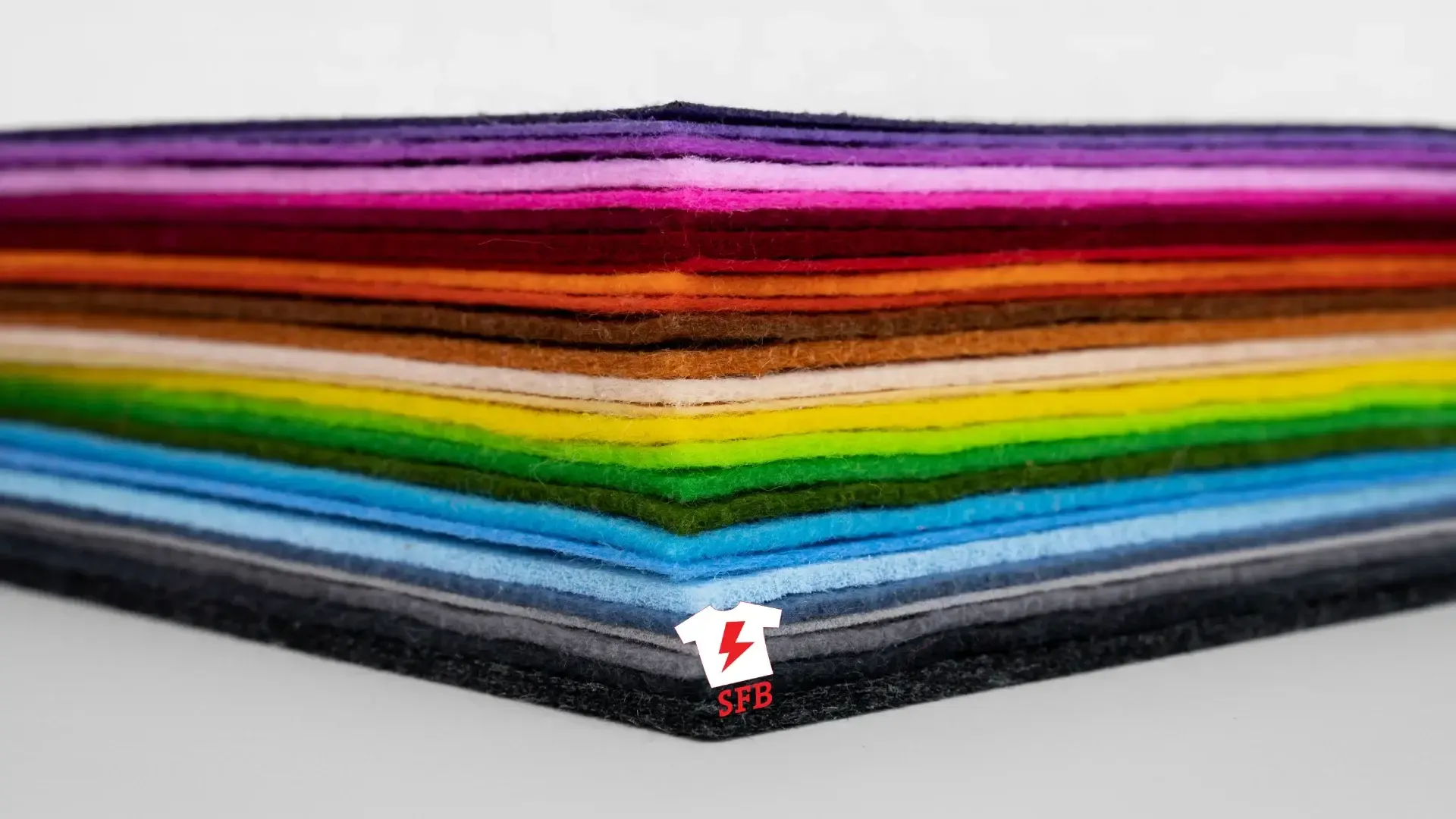 Pile de feutrines colorées aux teintes de l’arc-en-ciel, marquée du logo SFB